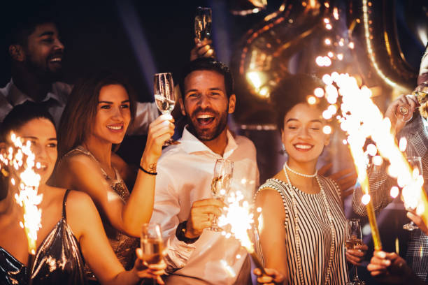 Shot of young friends holding sparklers at a party